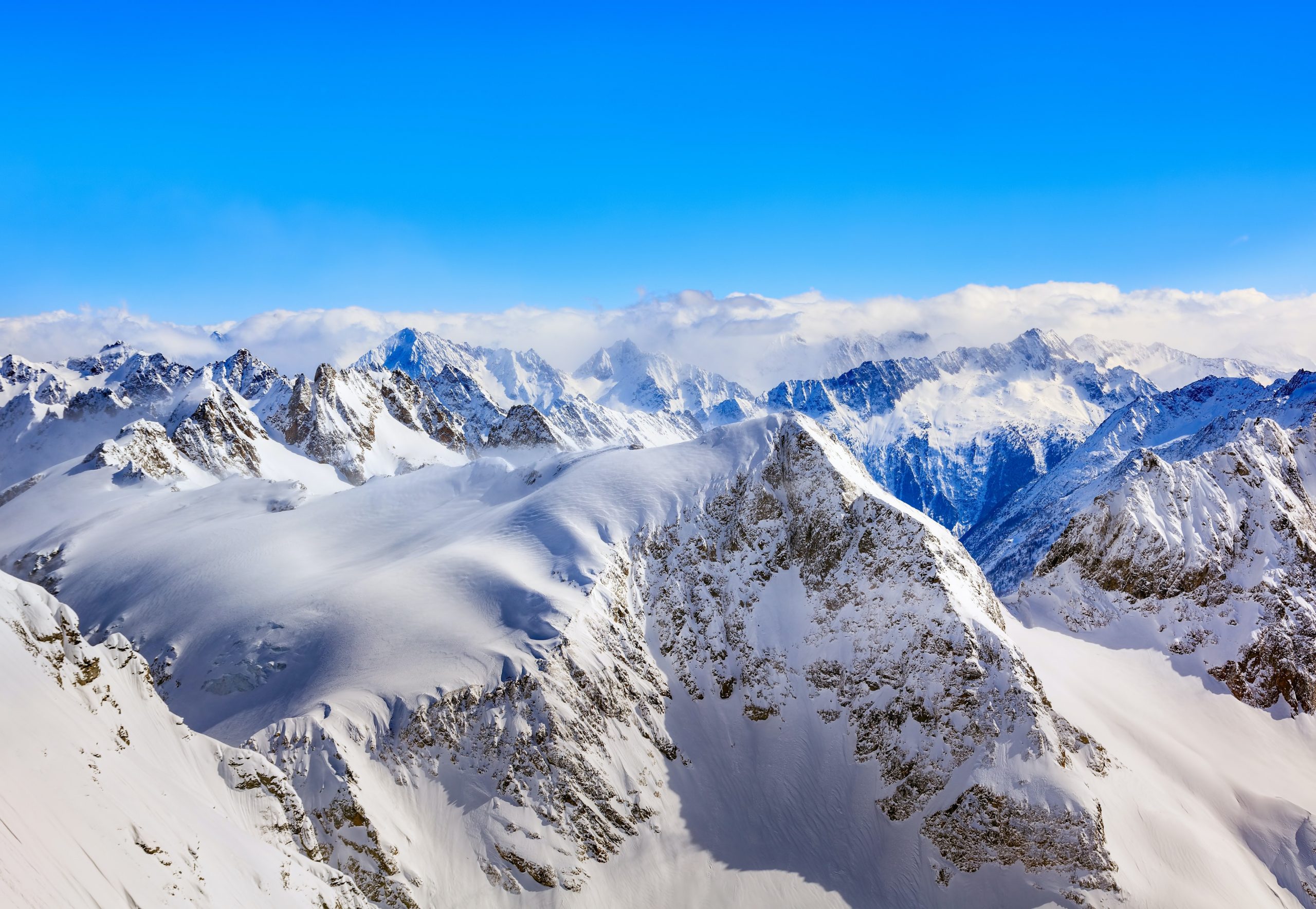 snow-covered swiss alps meeting blue sky