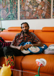 moyosore martins on an orange couch with flame pants