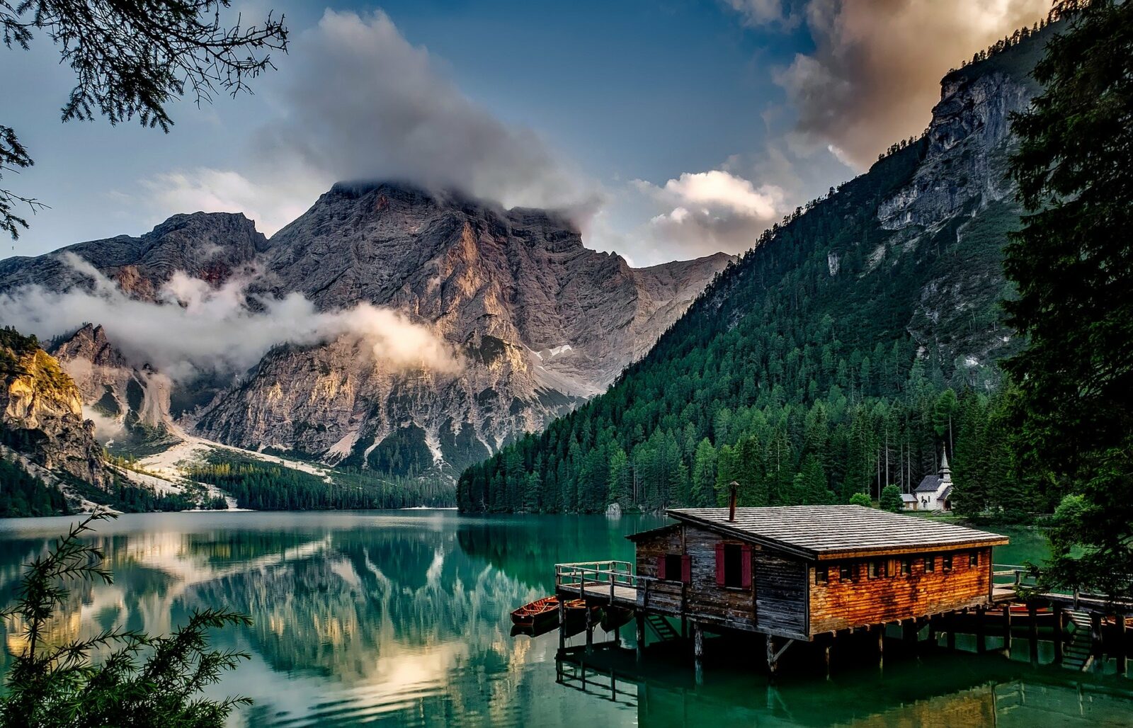 cabin on a lake in canada with mountains and pines in the background