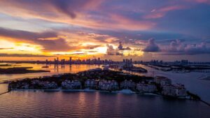 sunset setting over florida skyline and island luxury homes