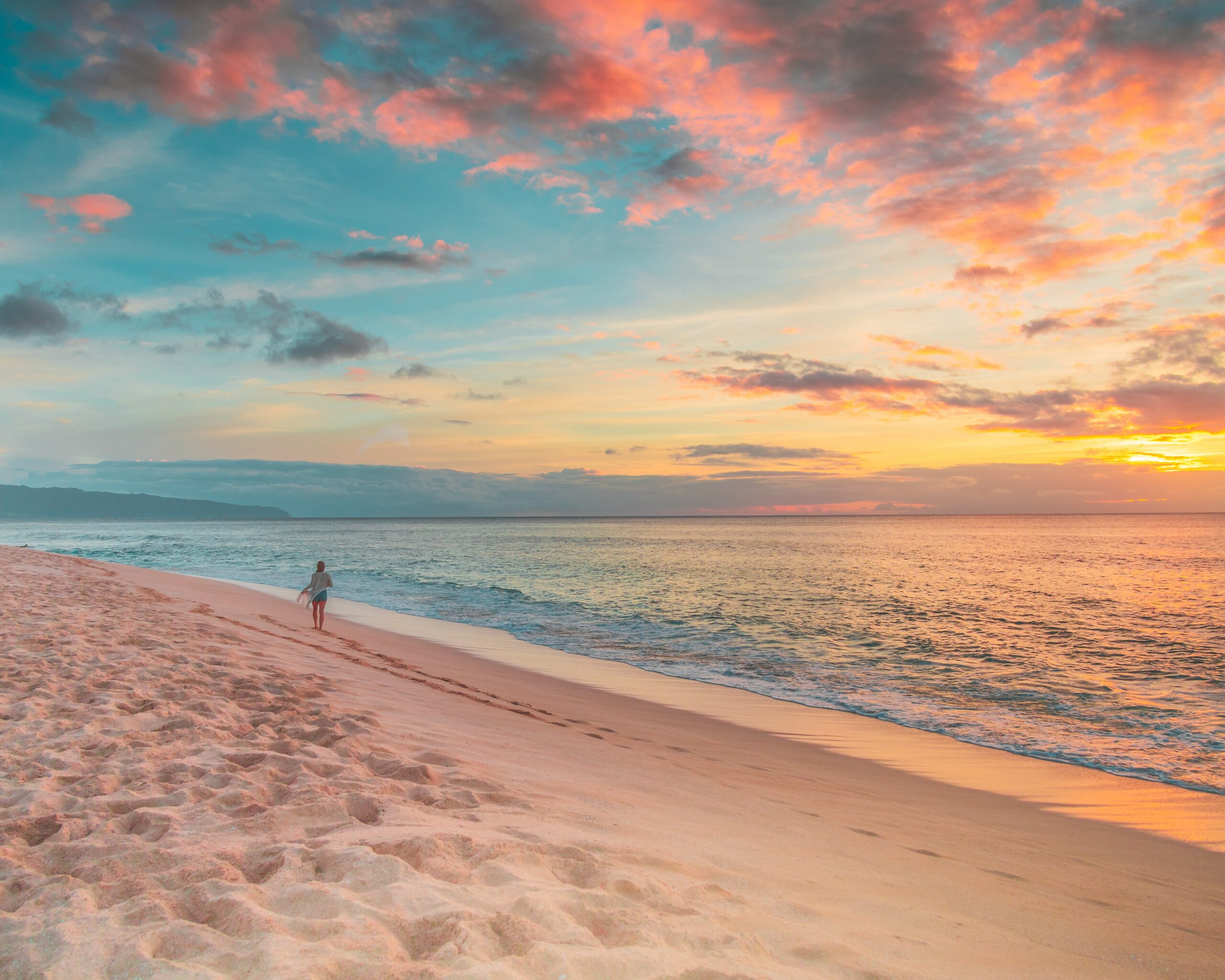walking along the sand in hawaii at sunset
