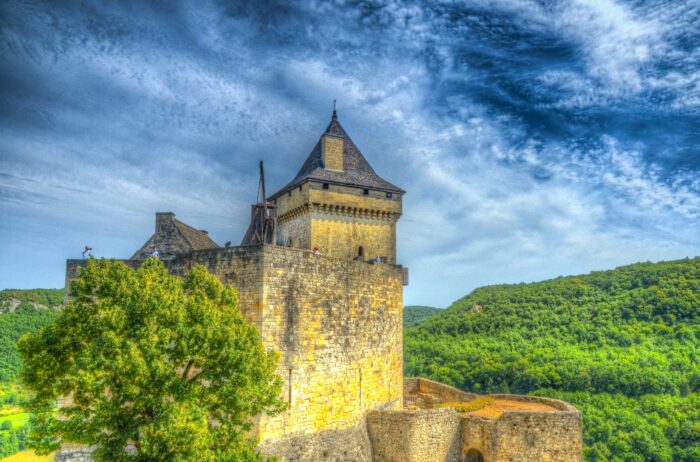 trees and blue sky surround a historic castle in france