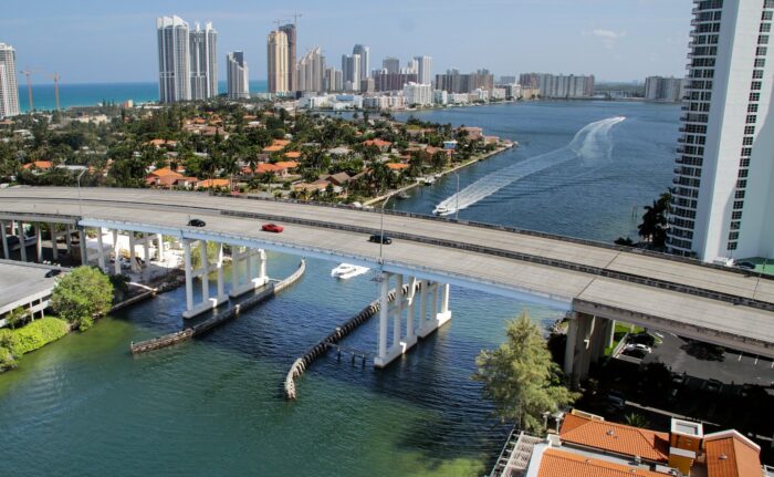 a bridge crosses over the waterway beneath luxury residential towers in miami beach, florida