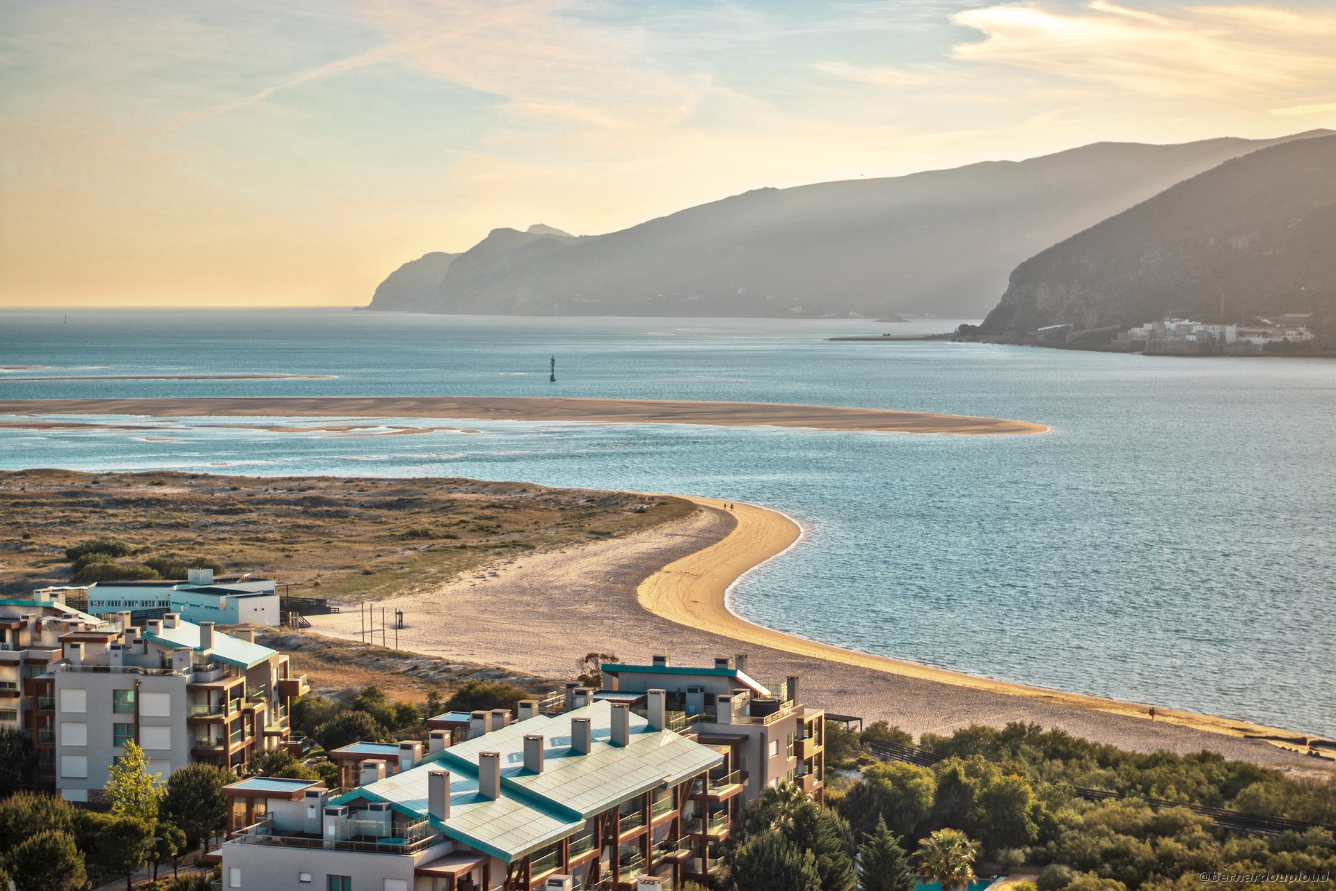 a row of luxury condominiums sit on the forefront of ocean and beaches in portugal