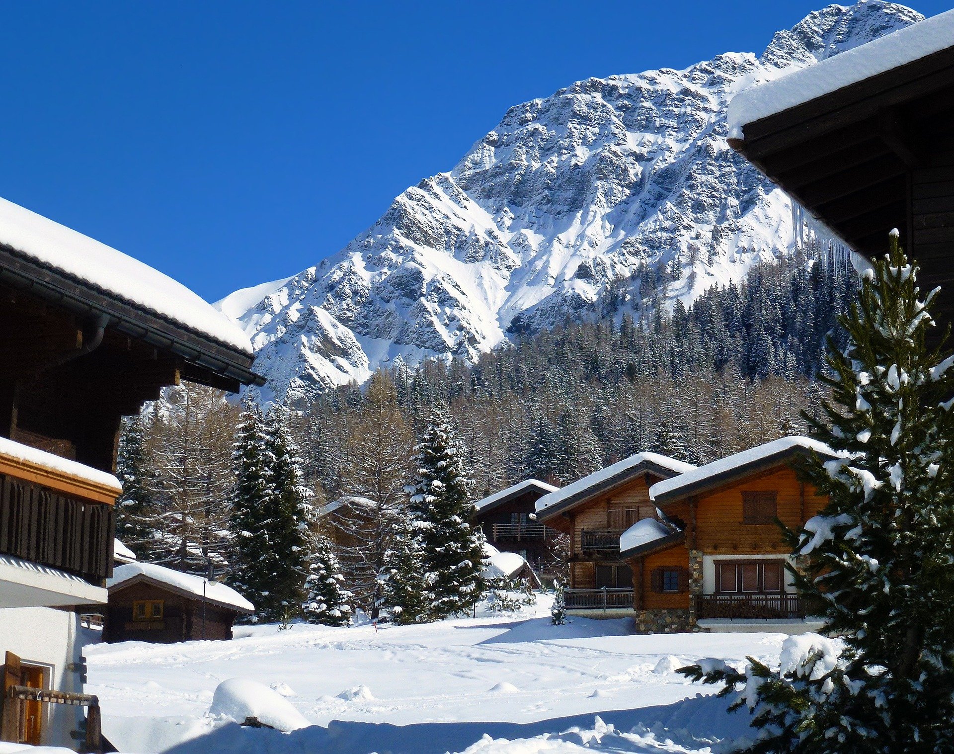 contemporary chalets covered in snow with mountains in background