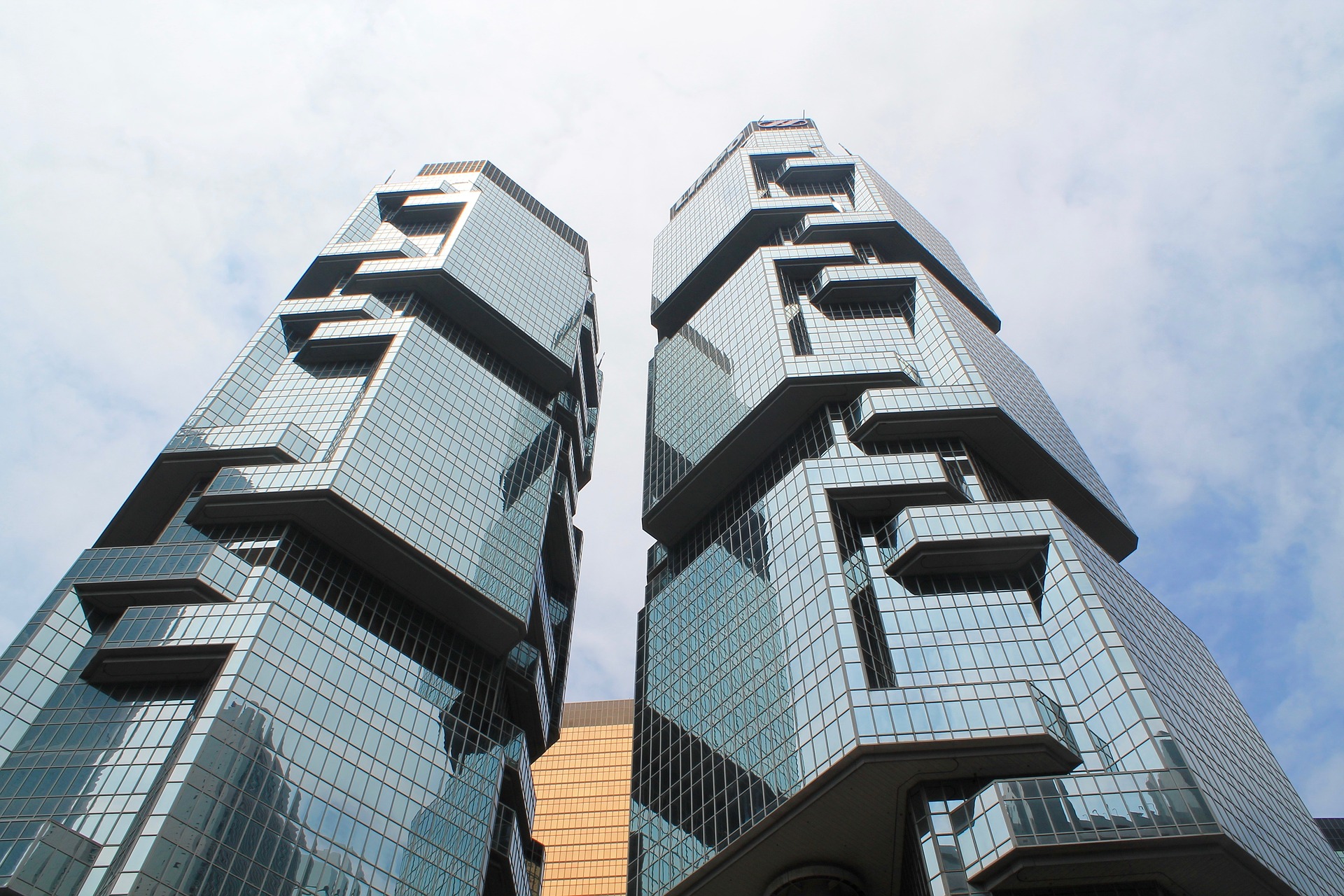 looking up at twin architectural buildings in the business section of Hong Kong