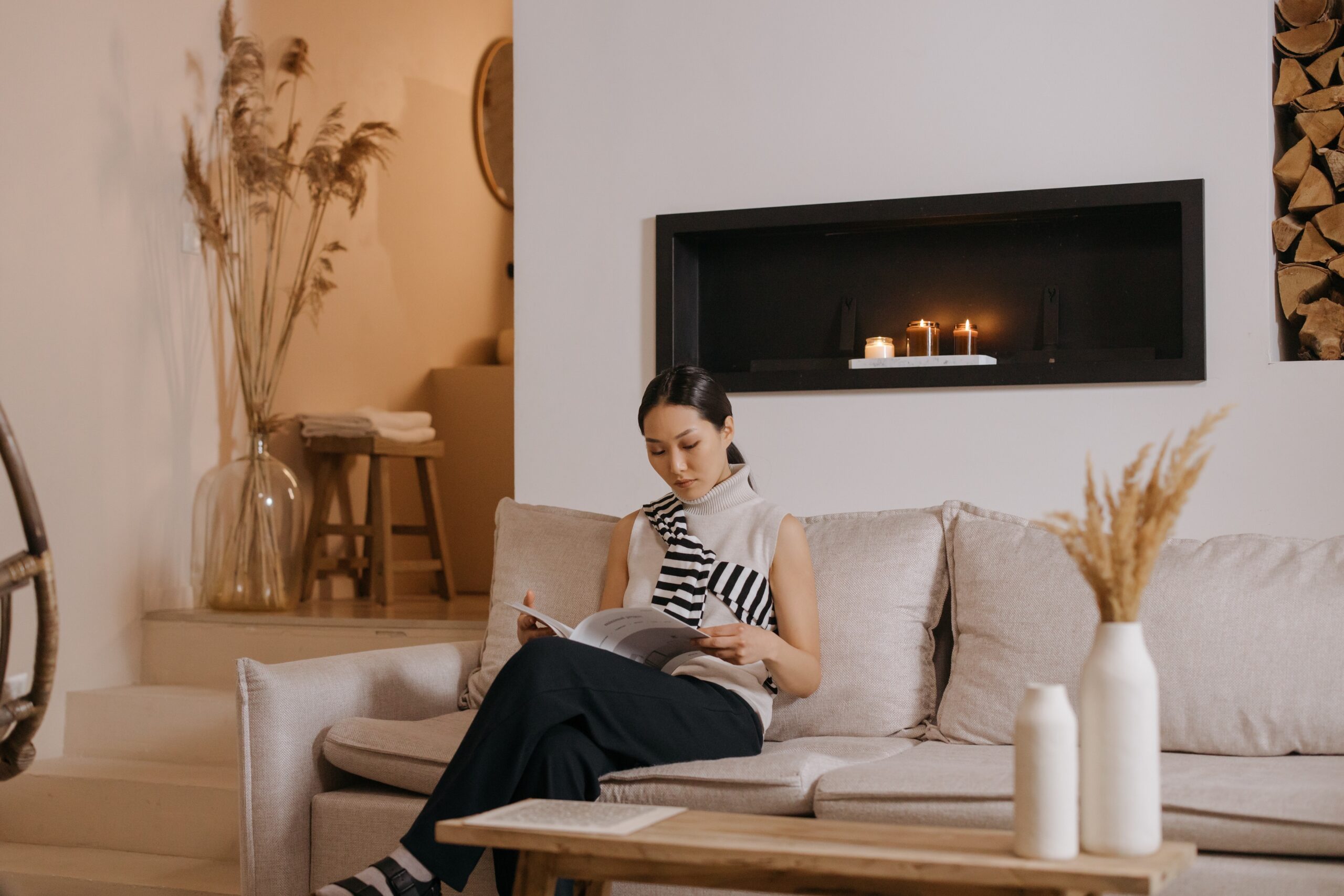 a woman looks at a magazine in a staged, modern living room