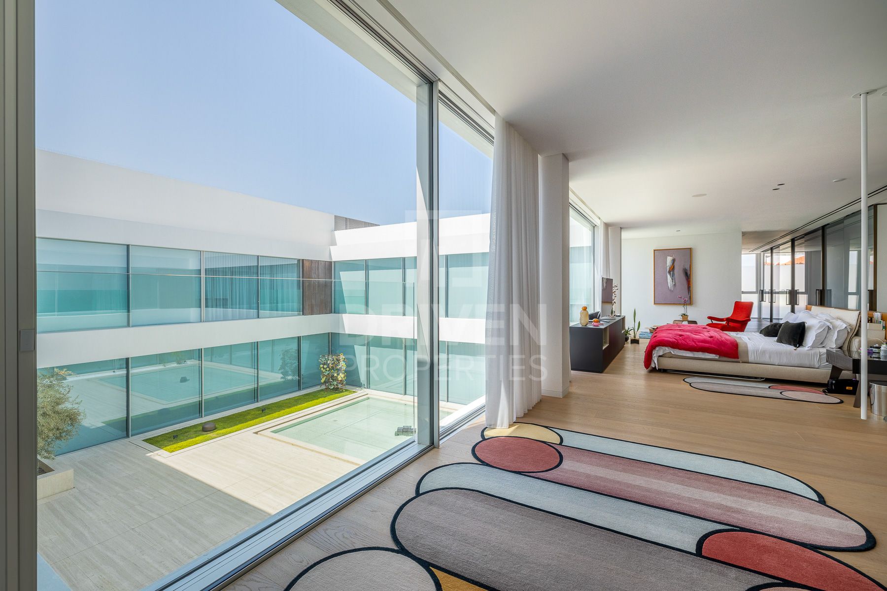 walls of glass enclose a bedroom inside a dubai villa