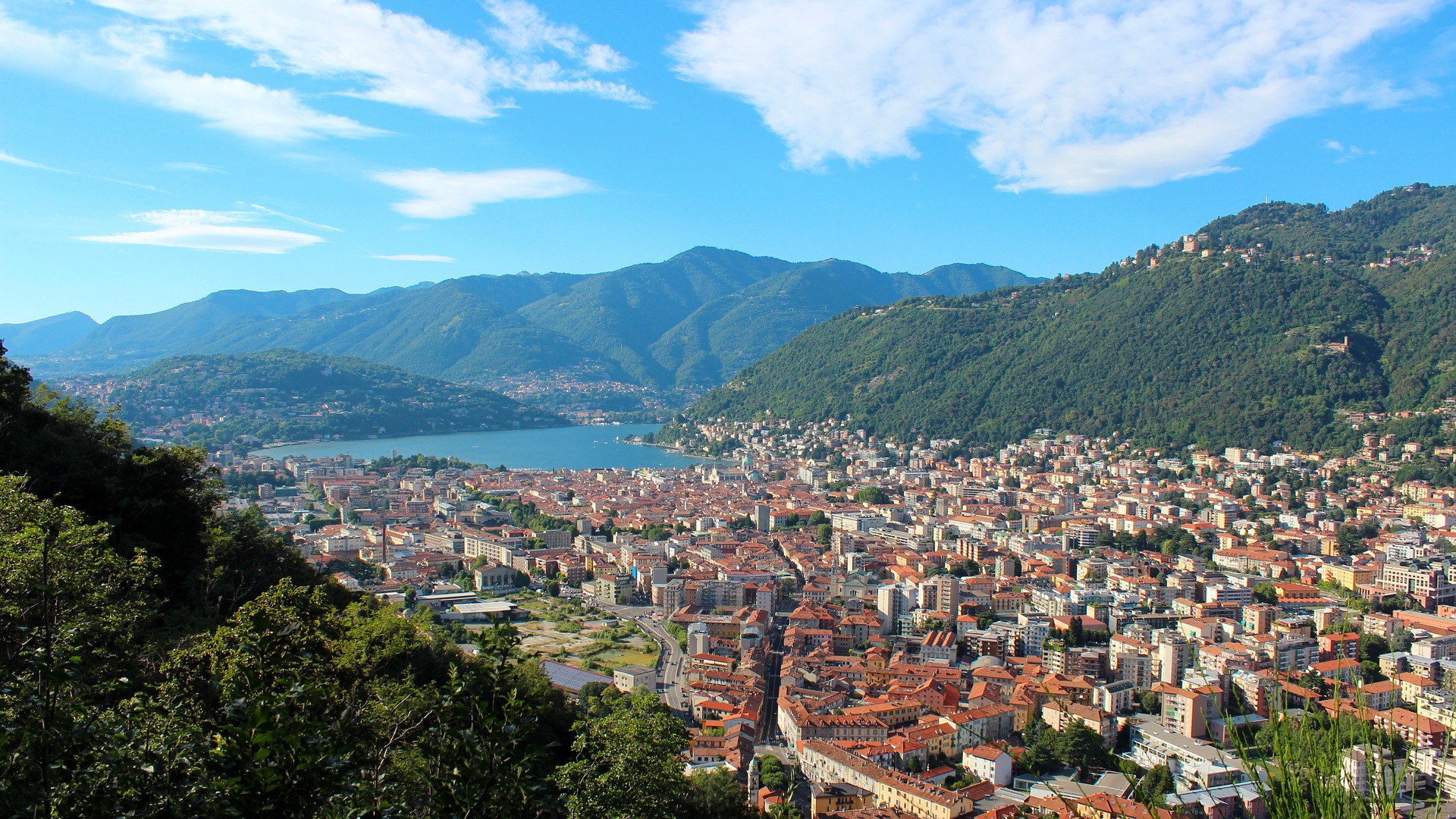 panoramic view of lake como in italy with blue sky meeting mountains, lake and township.