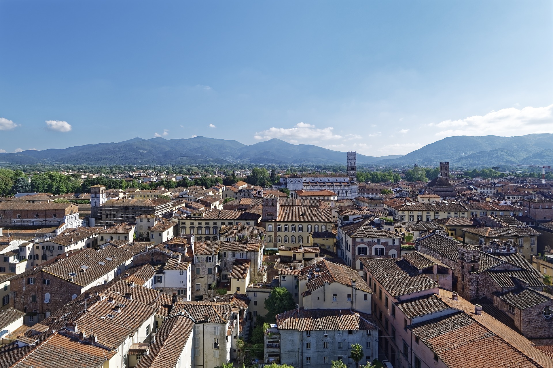 panoramic view of building rooftops and mountains in lucca, tuscany, italy