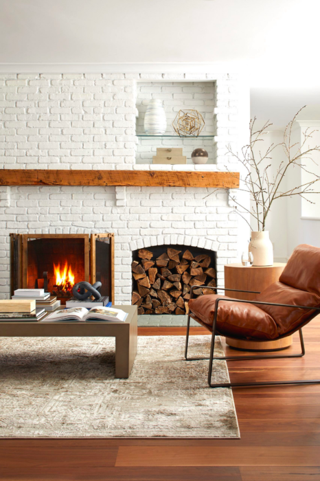 Interior view of a chair and coffee table with a fireplace.