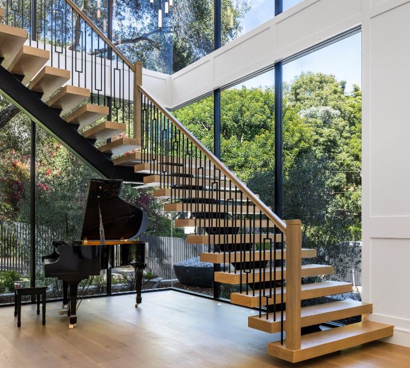 interior view of a modern staircase with a piano underneath