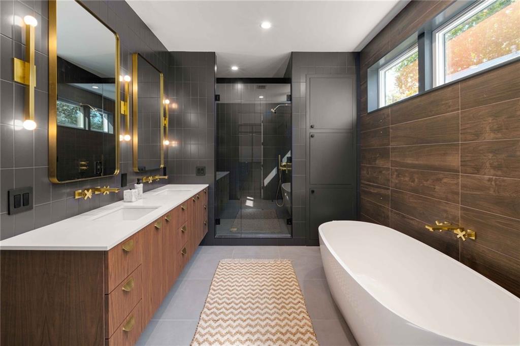 Freestanding tub in a black and wood bathroom.