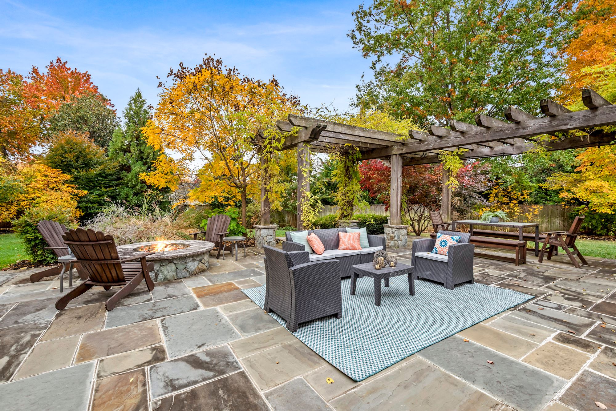 exterior view of the patio with a fire pit and chairs. 