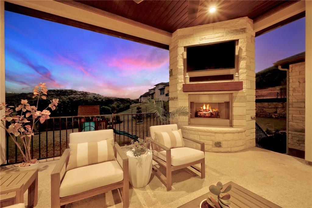 Exterior view of a fireplace with sunset in background and a tv stand.