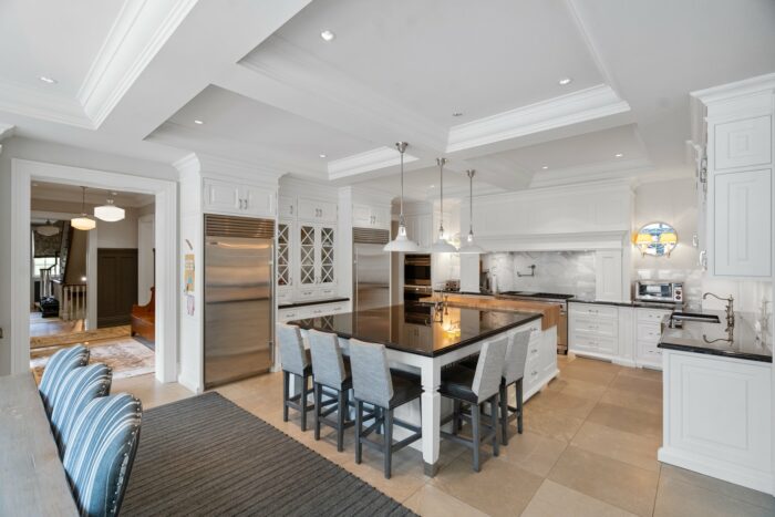 Open-concept kitchen with tasteful white cabinetry. 