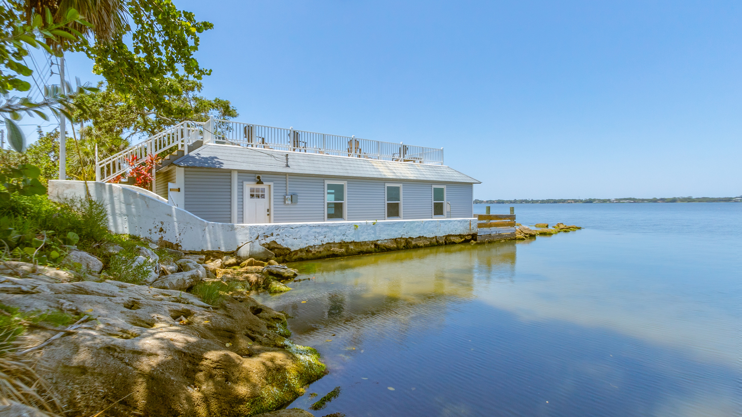 A boathouse sits on a river near a Florida estate