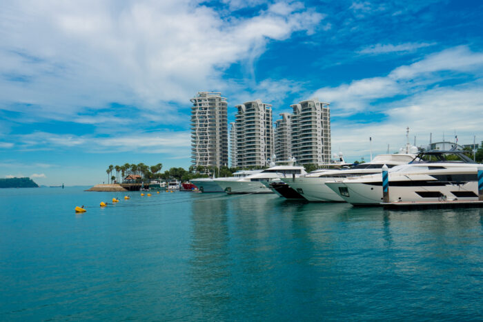 A few yachts in a row with a view looking out into the ocean.