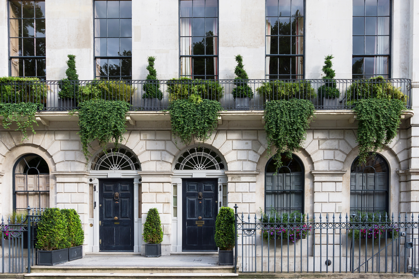 Luxurious old apartament house with a white facade and green plants, London, UK