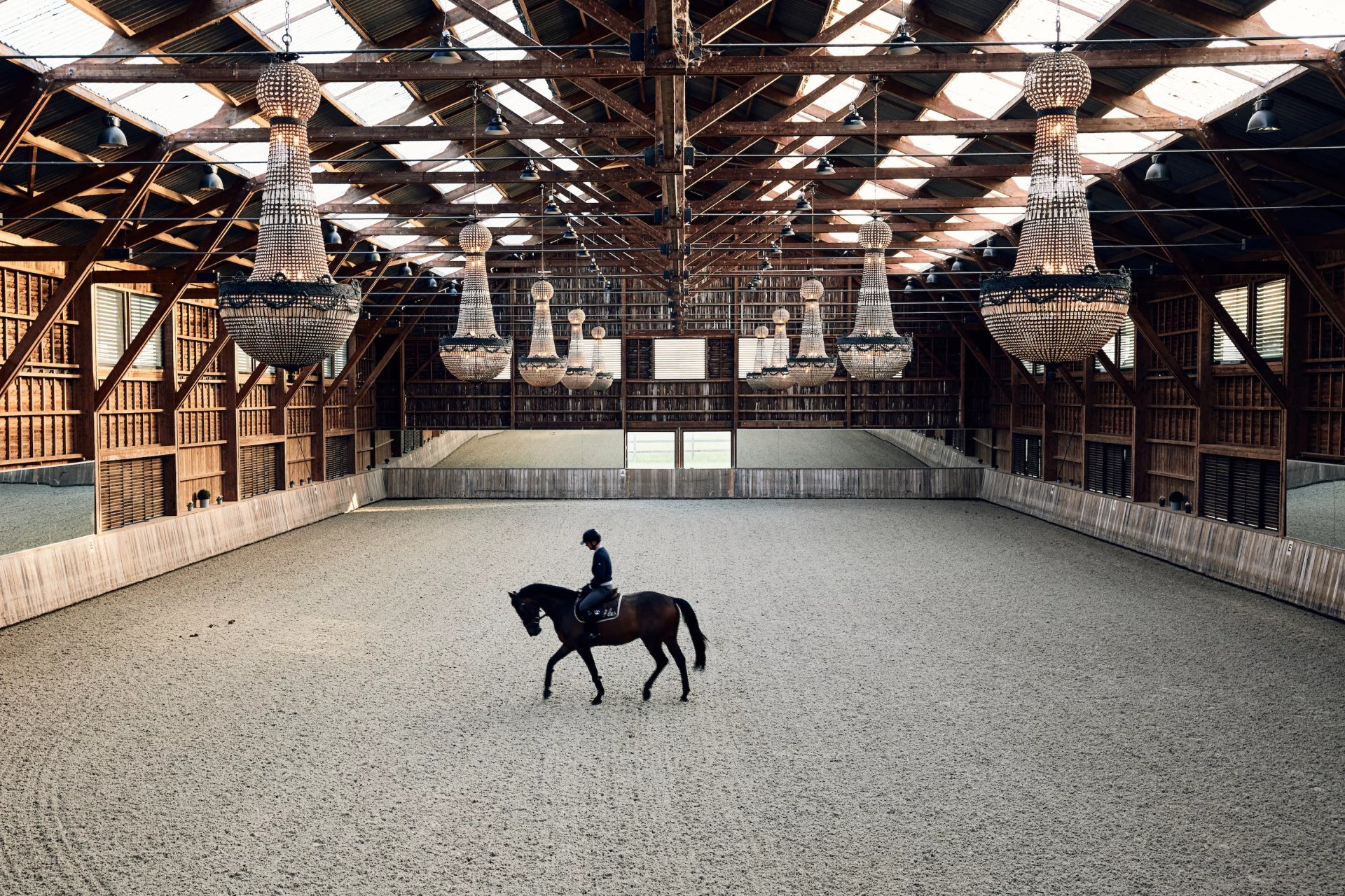 Indoor horse arena with chandeliers. 