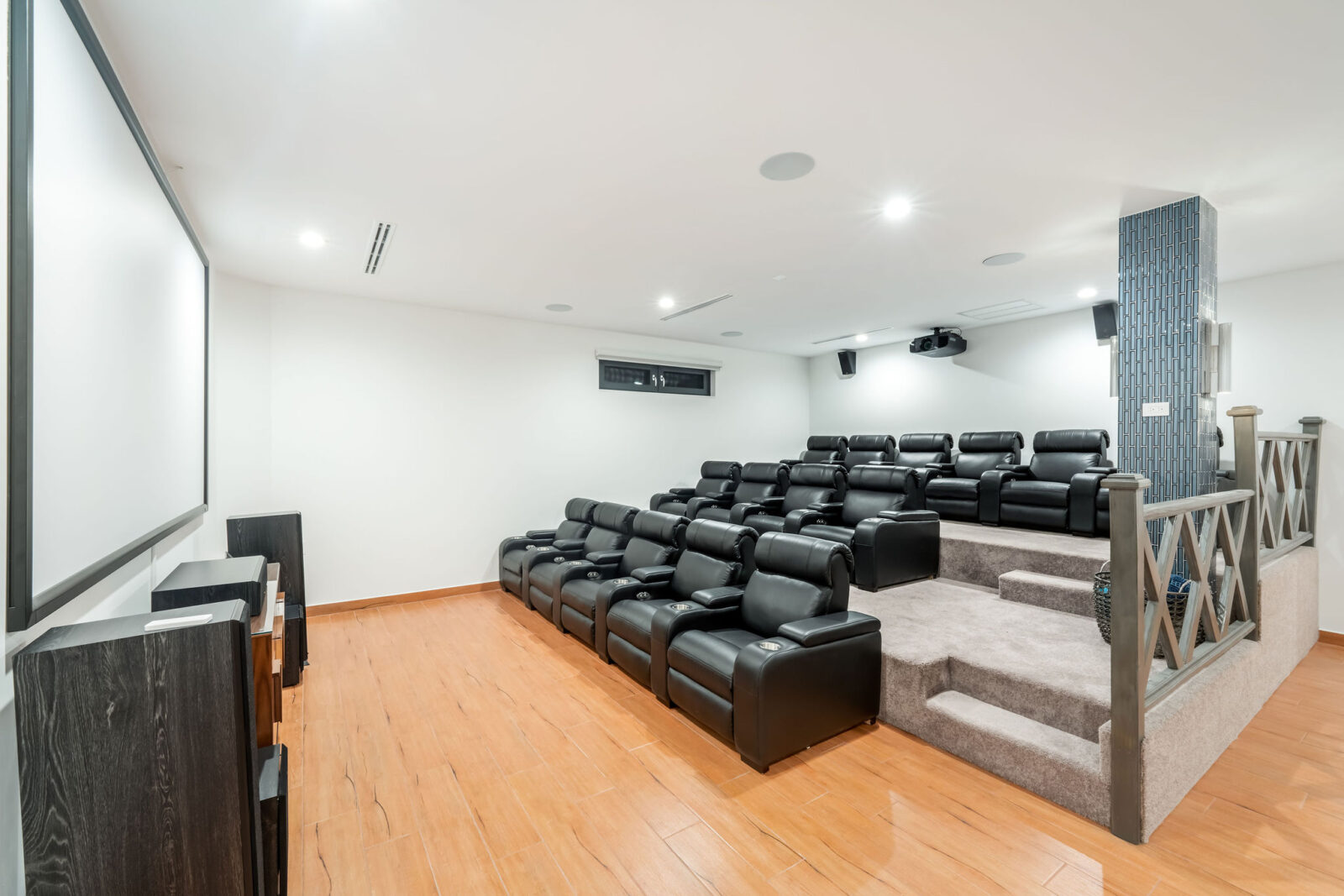 Fourteen Recliners lined up and facing a big projector screen.