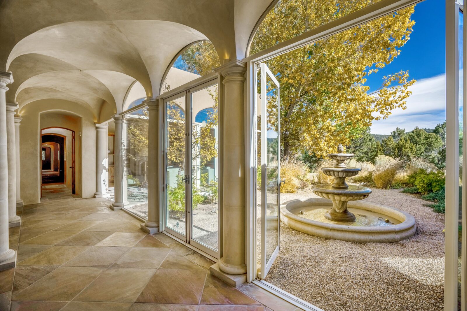 Walls of glass along the hallway open to a central courtyard with fountain. 