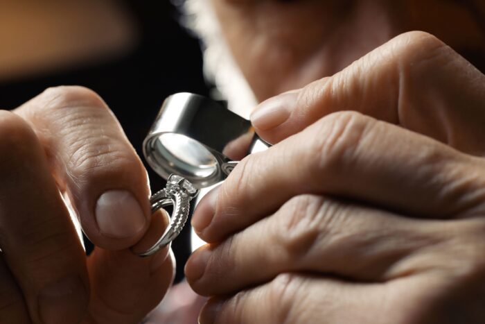 Jeweler inspecting diamond ring. 