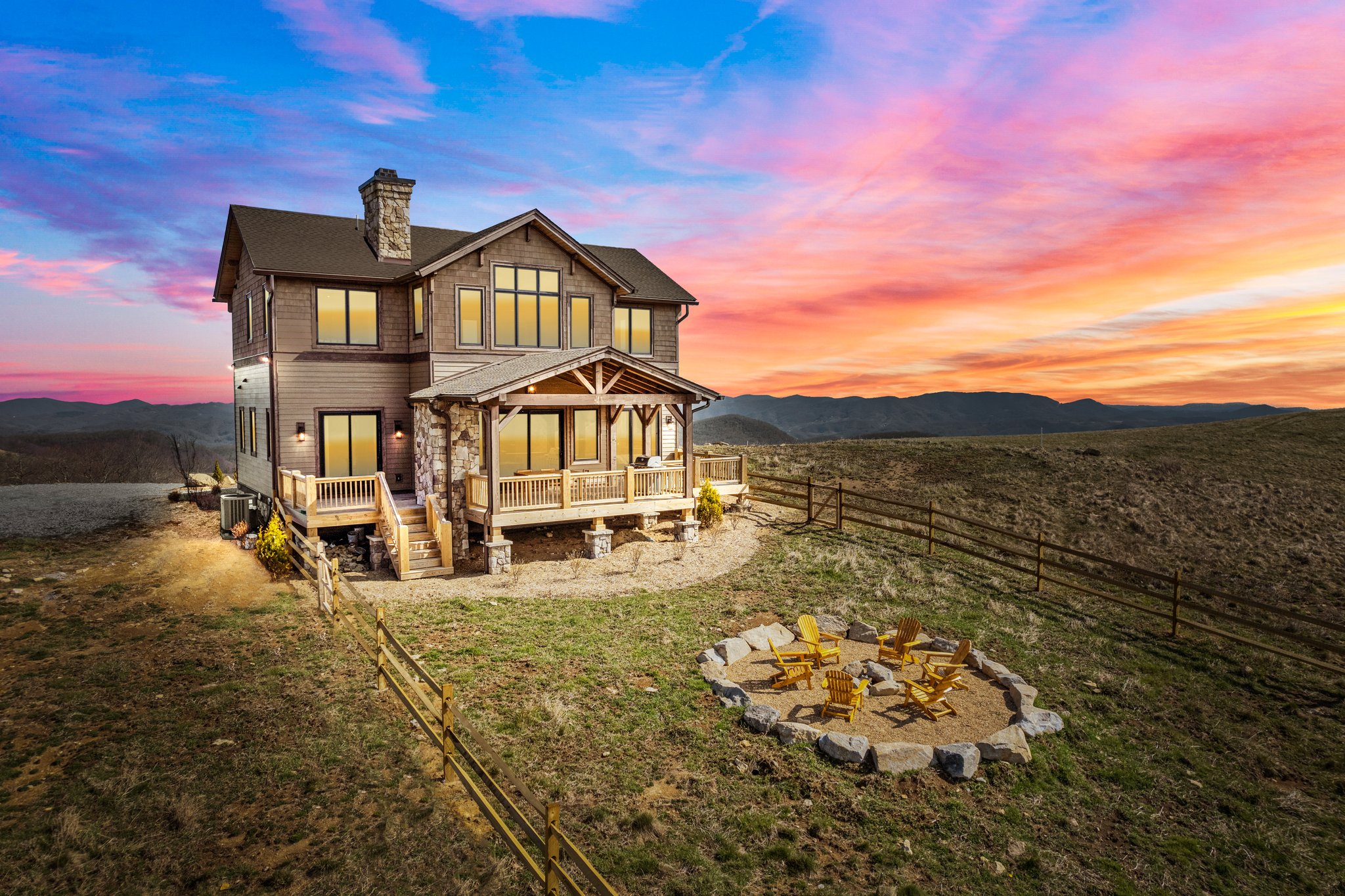 A two story house on a hill against an orange and purple sky.