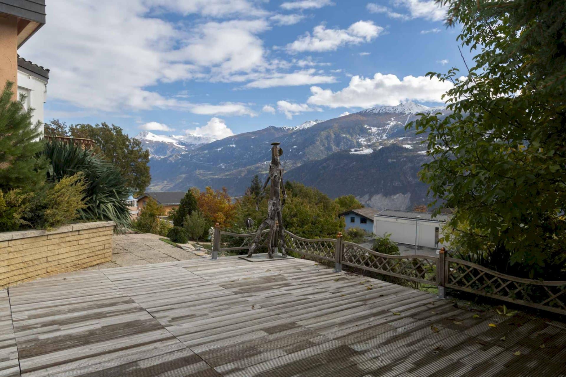 A stone walkway with a view of blue skies and a wide mountain in the distance.