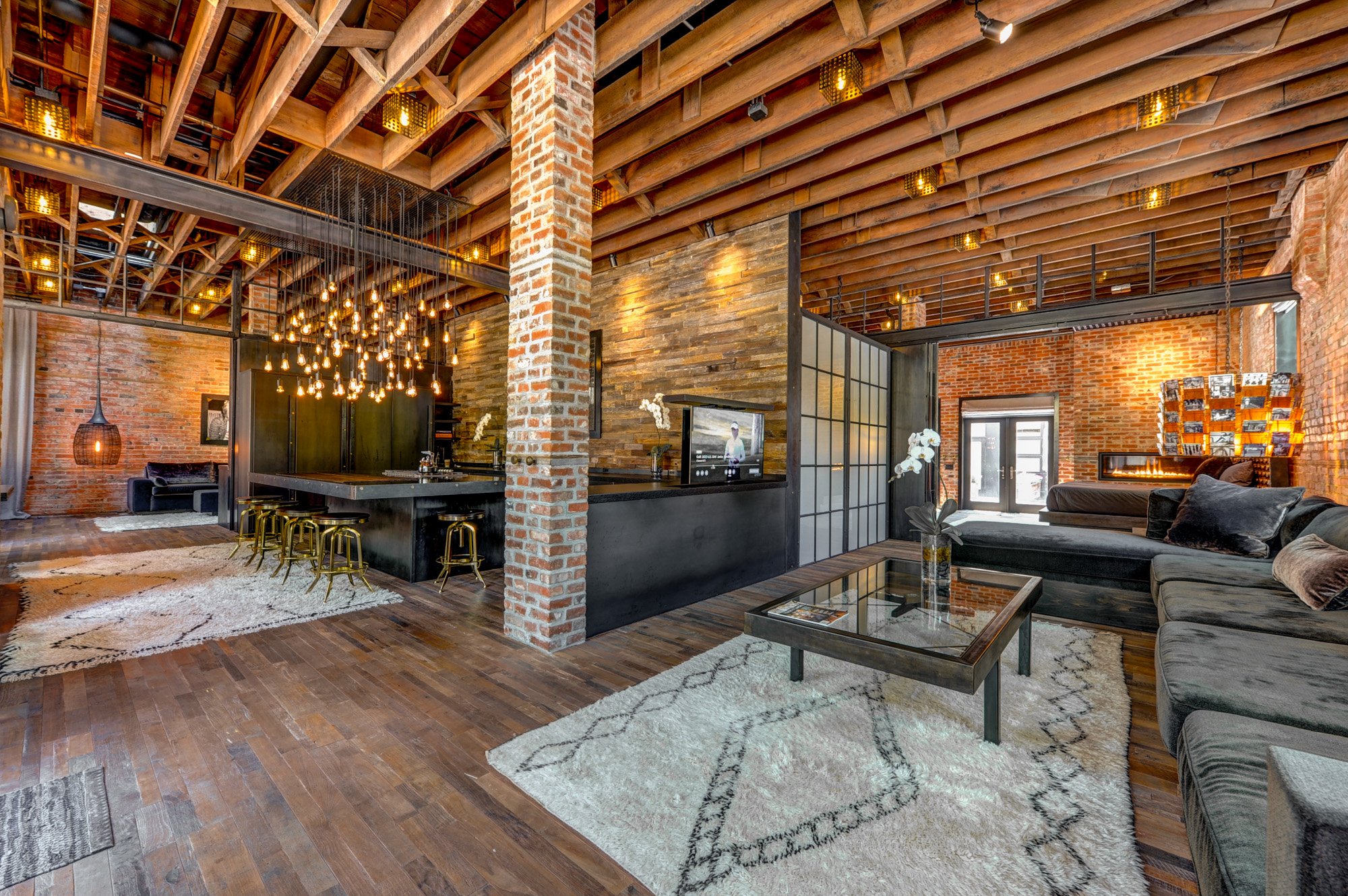 A wide, open, living space with brick pillars and brick walls on all sides.