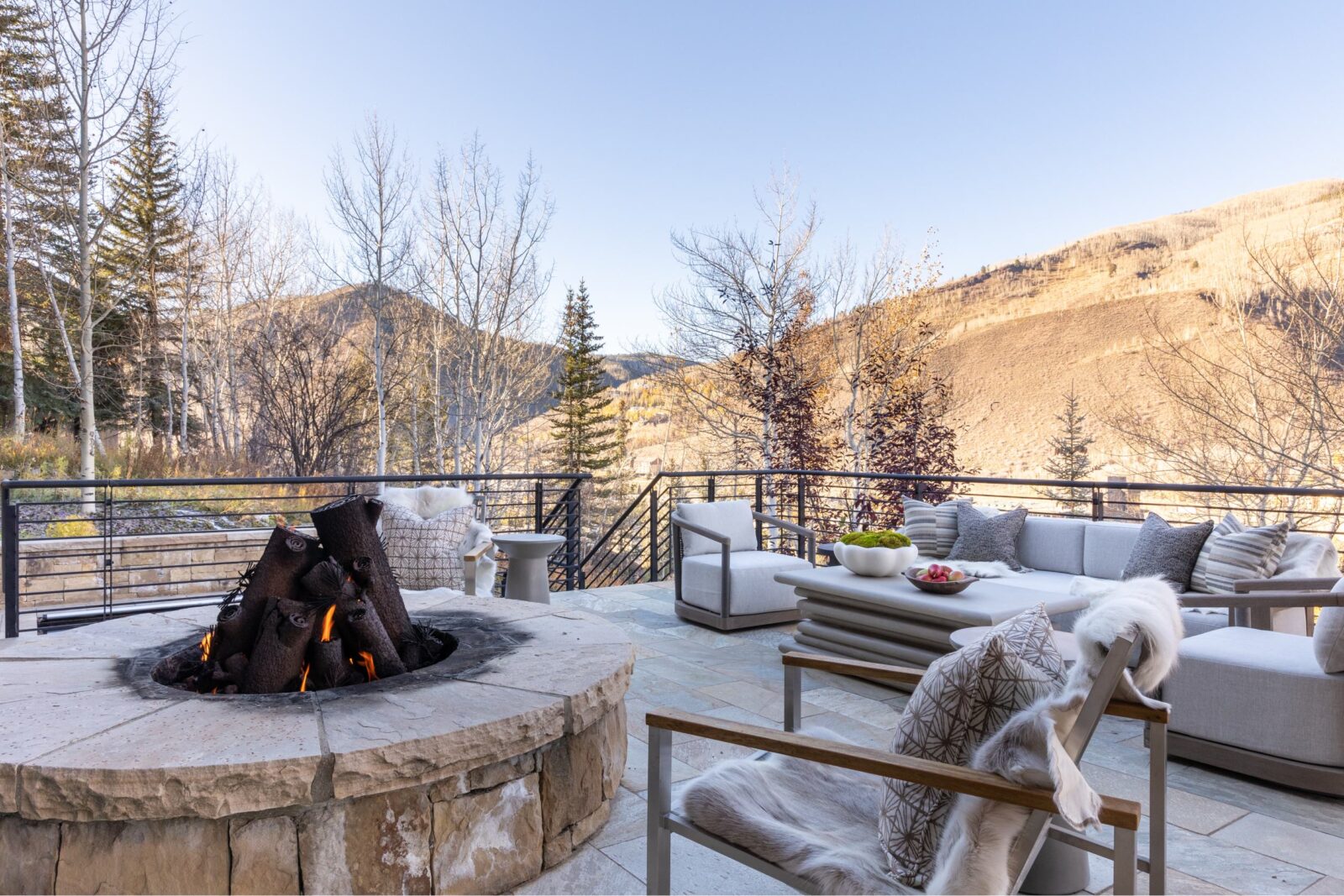 Outdoor firepit centers an expansive patio with views of Gore Range. 