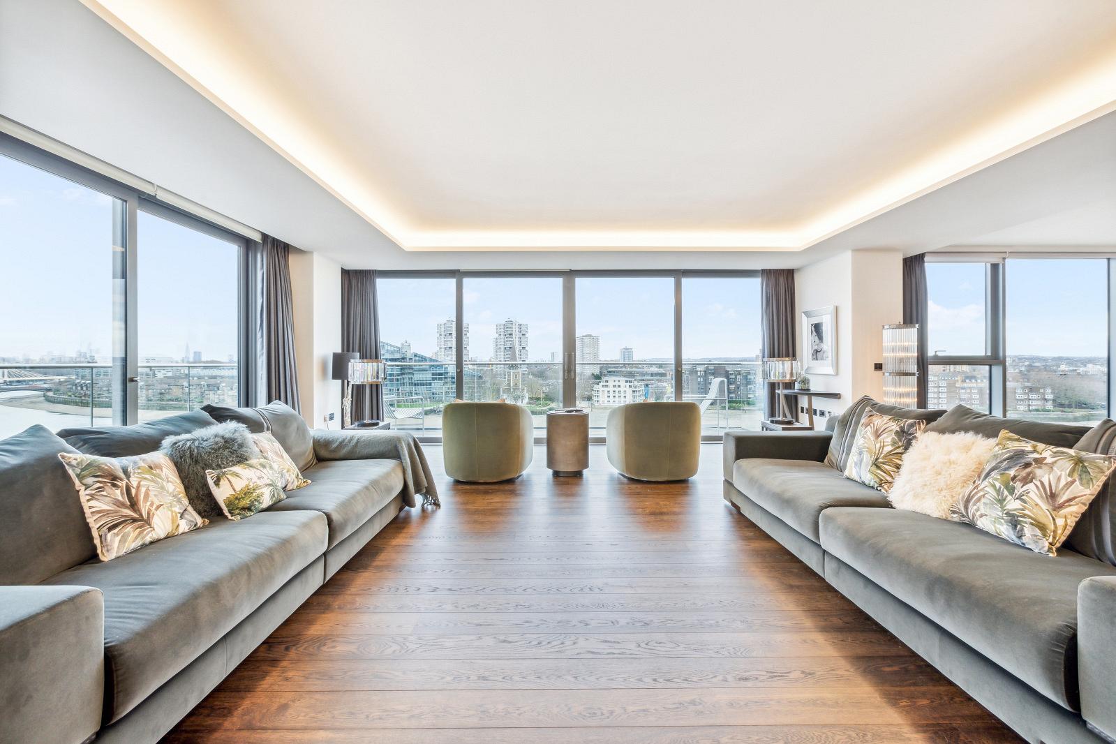 Open living area with walls of glass with views of the River Thames. 