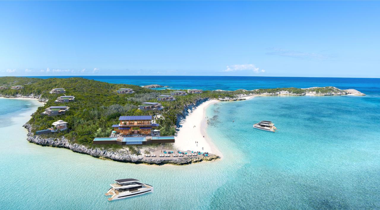 An island in the bahamas with several big houses on it and boats in the water.