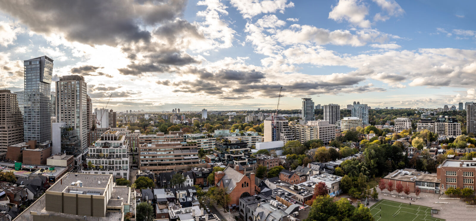 Many buildings in Toronto under a cloud speckled sky.