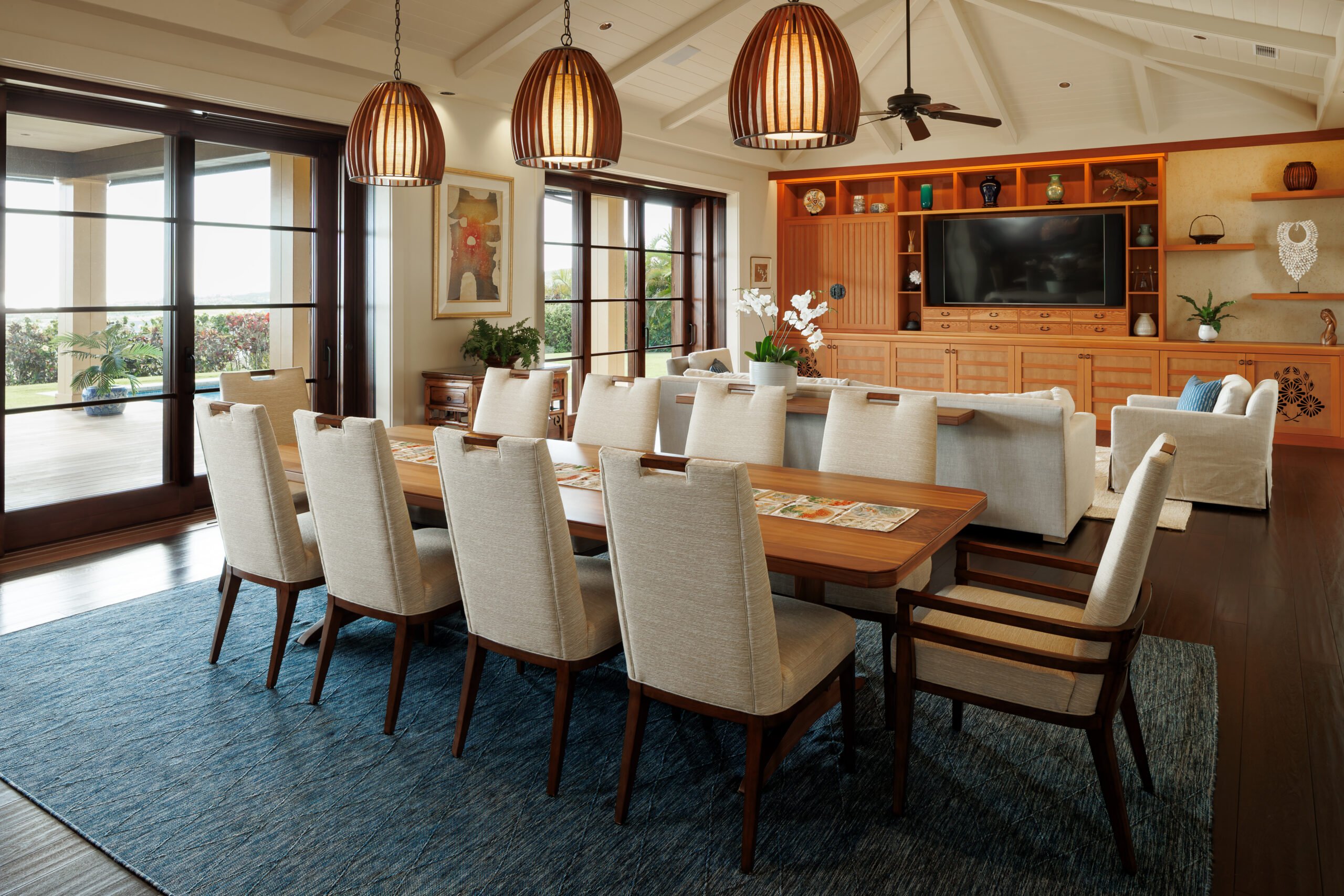 Open-concept dining room and living area with wall of sliding glass doors. 