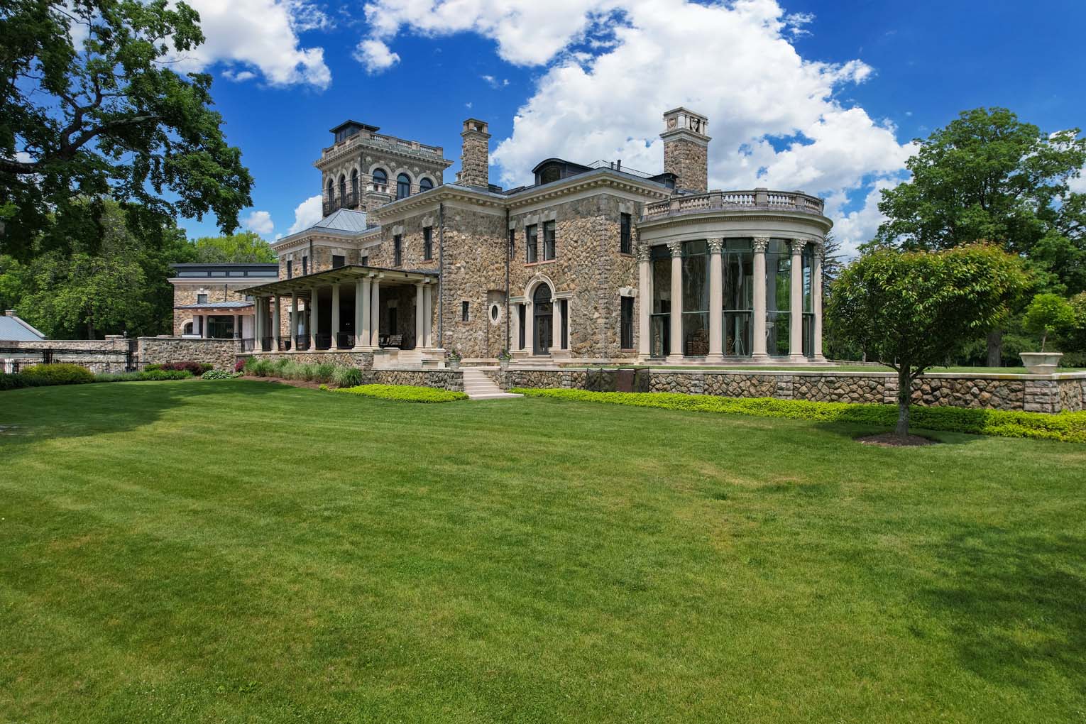 A big stone house with pillars in its unique older design.
