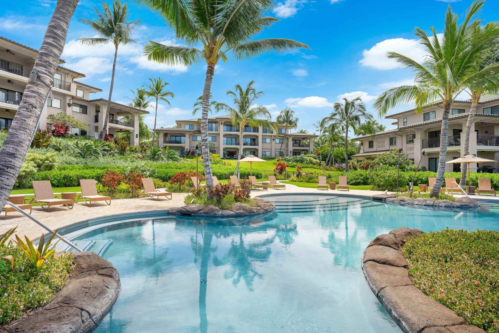 Three big housing units centered around a clear blue pool.