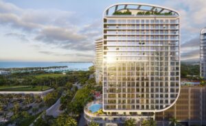 A tall glass building with a view of the water behind it.