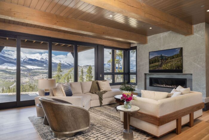 Living area with walls of glass and sweeping mountain views. 