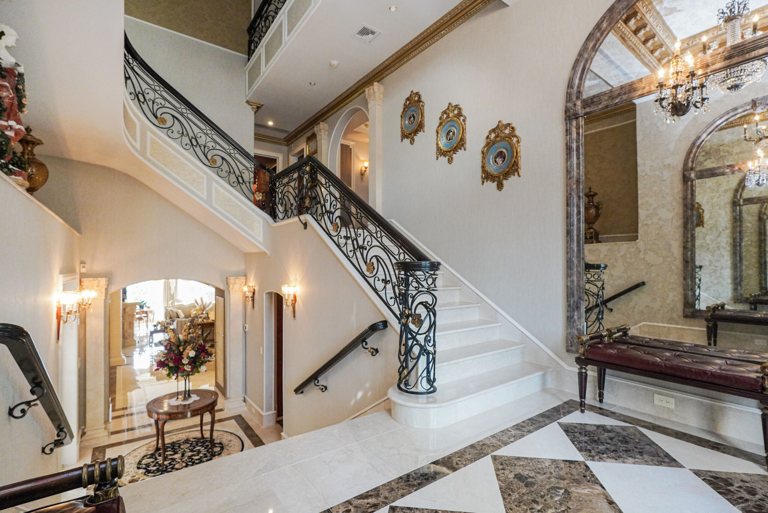 Foyer with marble flooring and gold trim work. 