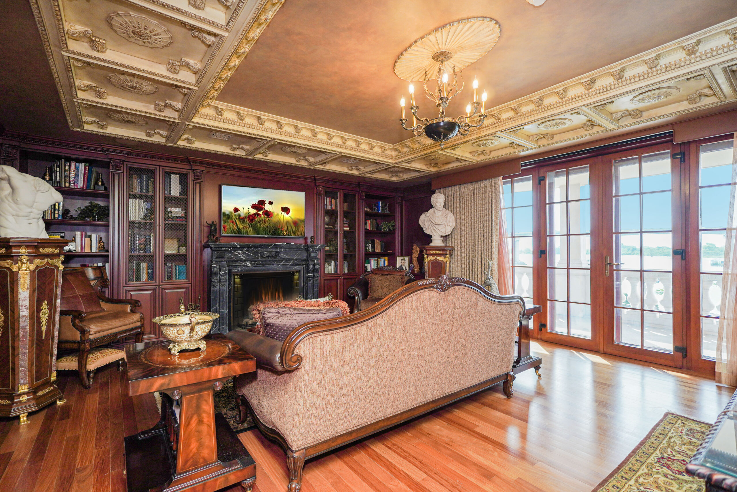 Parlor with built in bookshelves and elaborate ceiling molding. 